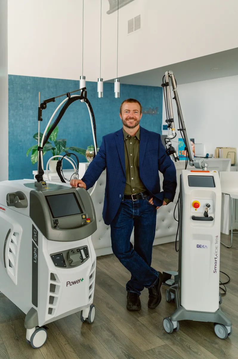 A Waterloo Medical Cosmetics team member beside clinic laser equipment